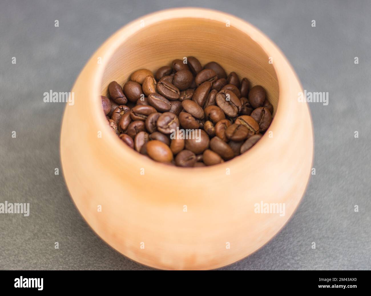 Granos de café en tazón de arcilla. Café tostado marrón. Bebida con cafeína.  Cafetería. Bebidas aromáticas. Granos de café bajo la luz del sol. Bebidas  por la mañana. Taza arábica Fotografía de