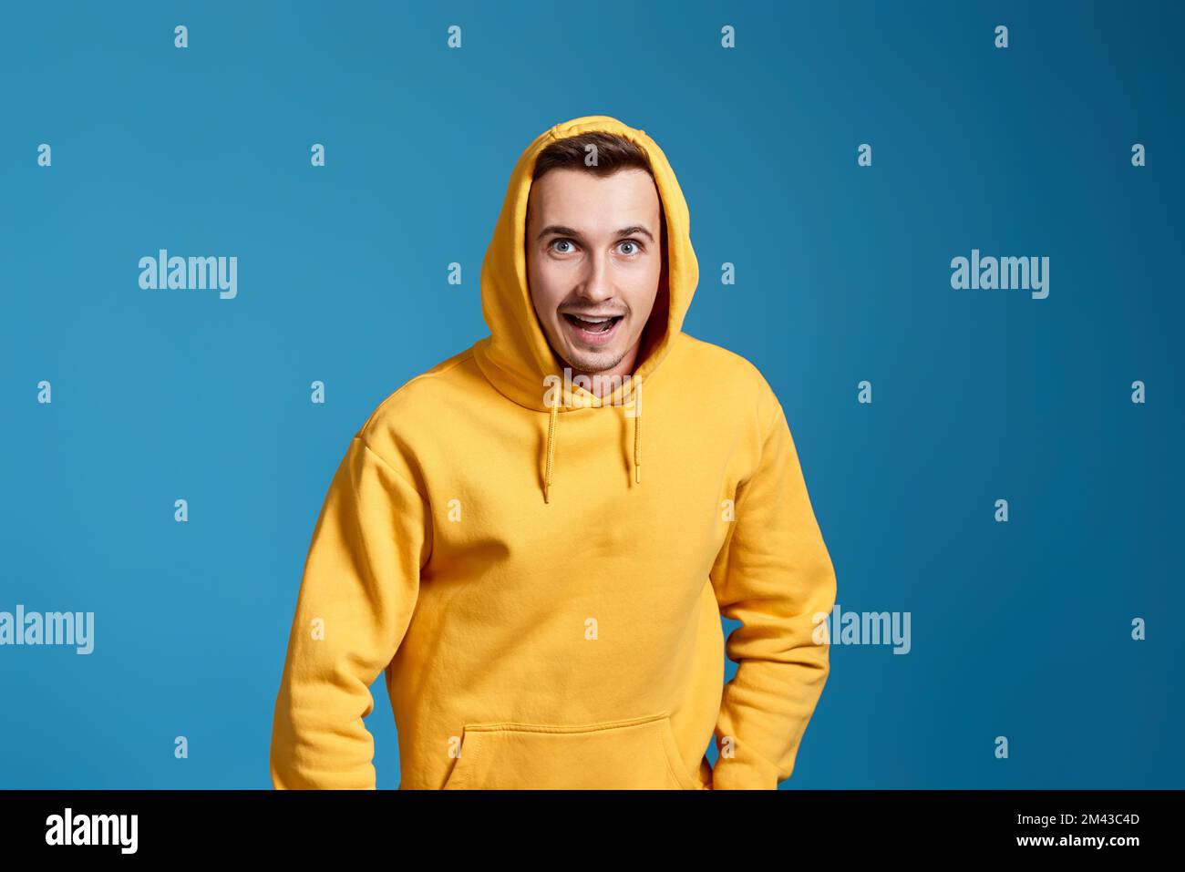 hombre guapo positivo en sudadera amarilla en azul Fotografía de stock -  Alamy
