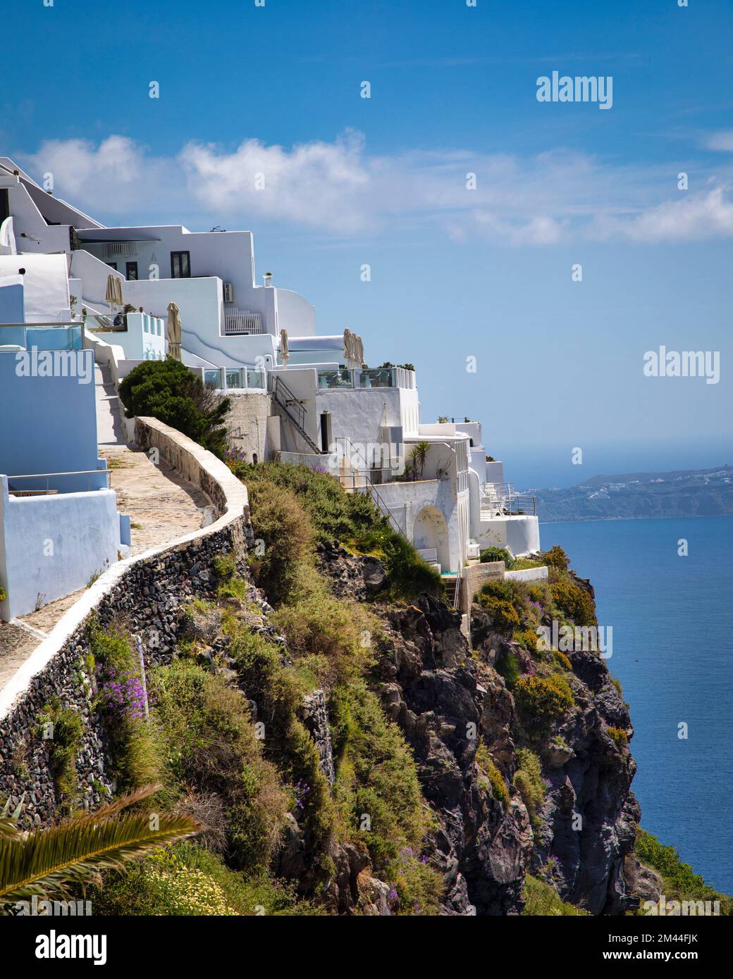 Hoteles y casas caen en cascada por los acantilados de la caldera en Firostefani en Santorini, Grecia. Foto de stock