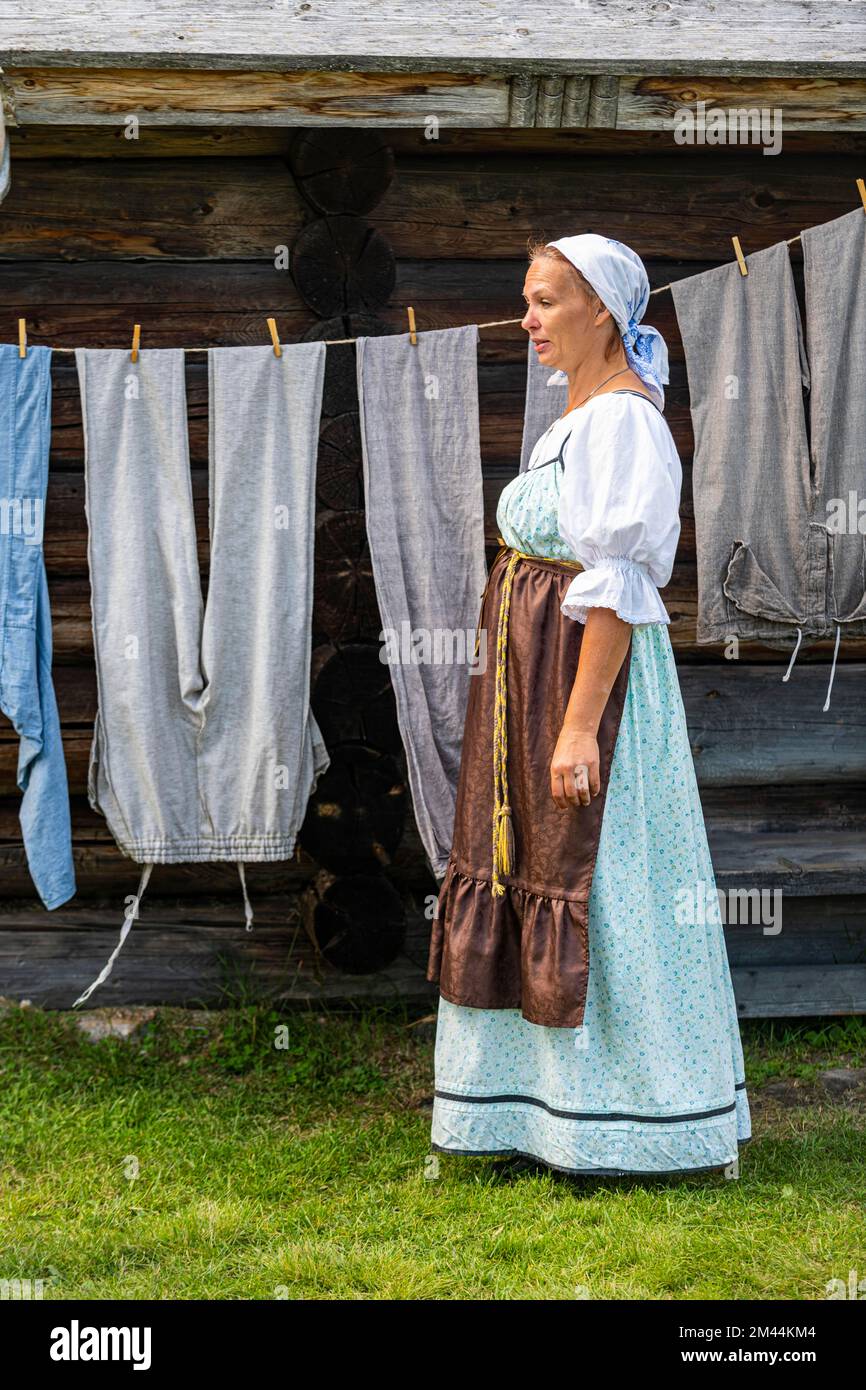 Traditionla vestida a las mujeres lavándose las manos, sitio de la UNESCO en la isla de Kizhi, Karelia, Rusia Foto de stock