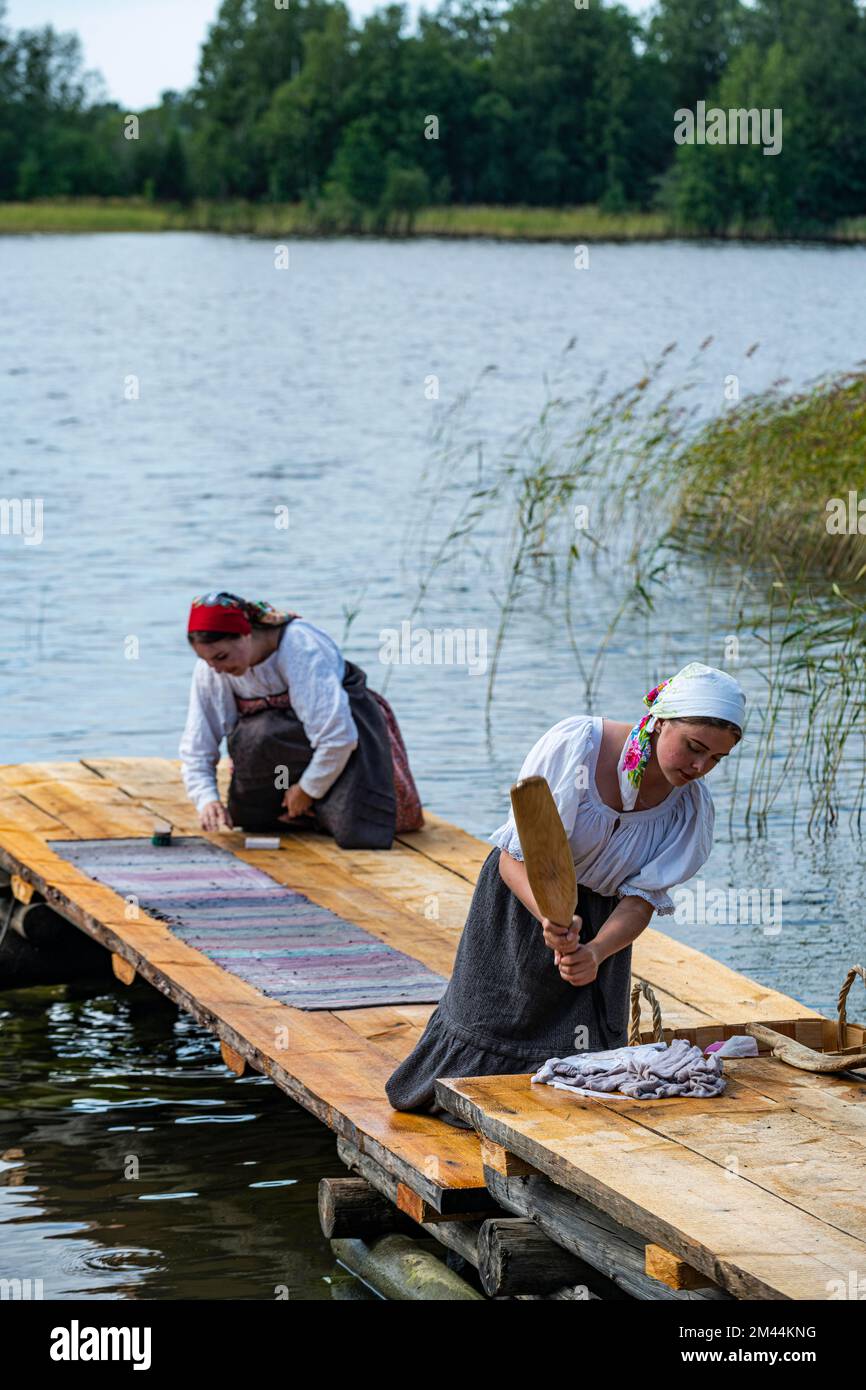 Traditionla vestida a las mujeres lavándose las manos, sitio de la UNESCO en la isla de Kizhi, Karelia, Rusia Foto de stock