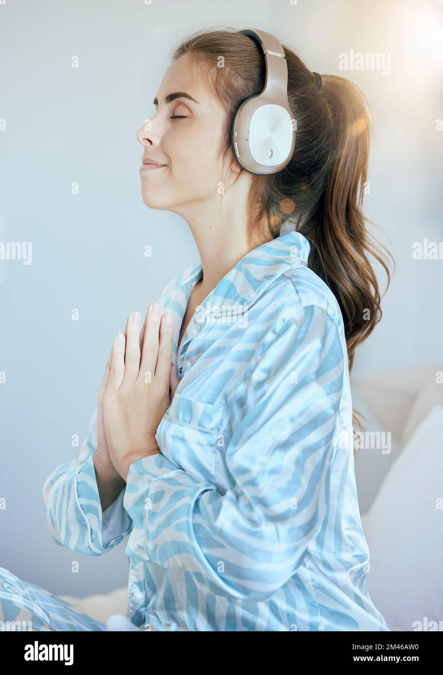 Auriculares, oración o mujer en meditación en el dormitorio que transmite  música zen relajante, podcast de yoga o radio en casa. Mañana, paz o calma  espiritual Fotografía de stock - Alamy