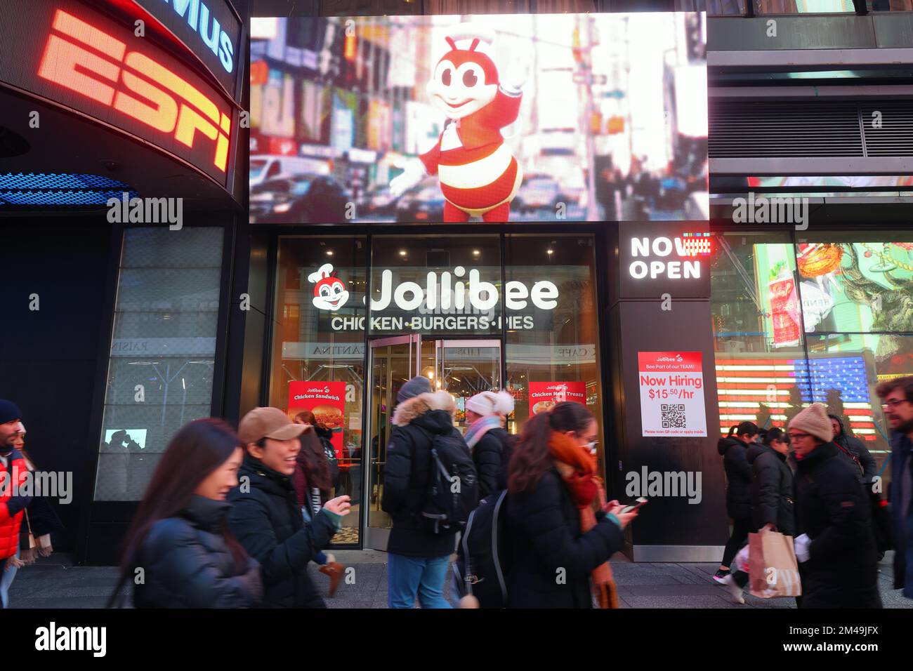 La gente paseando pasa por Jollibee Times Square en la ciudad de Nueva York. Jollibee es un restaurante de comida rápida de pollo frito filipino. Foto de stock