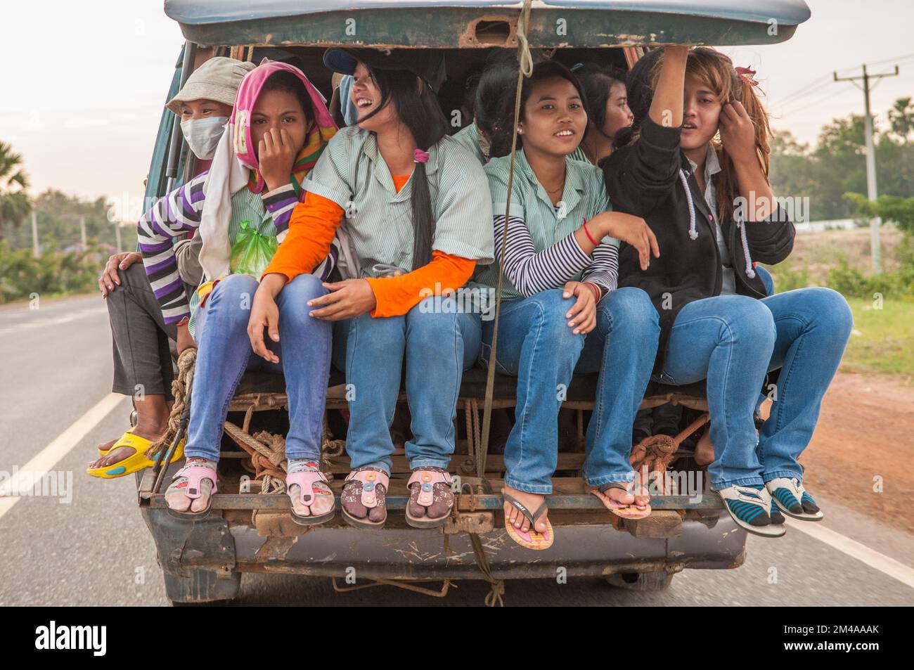 Las mujeres camboyanas, las trabajadoras de la ropa, embaladas en la parte  trasera de una furgoneta con jeans azules vaqueros y chanclas. Provincia de  Kampong Speu, Camboya. © Kraig Lieb Fotografía de