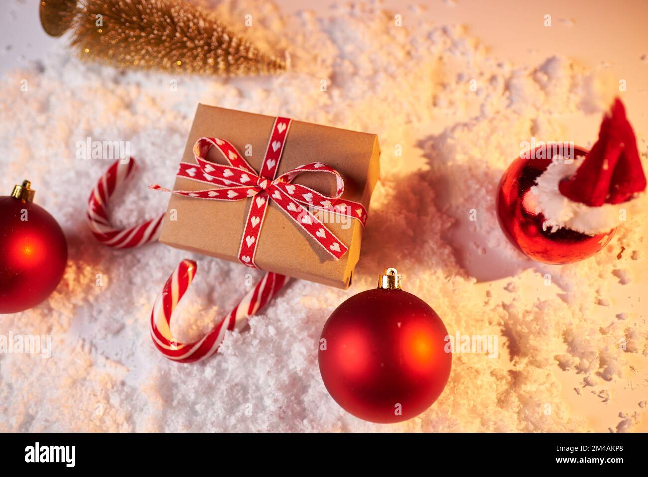Concepto de Navidad, trineo de Santa de regalo rojo y bastones de caramelo sobre fondo rojo, regalo para las vacaciones de invierno, espacio de copia. Foto de stock