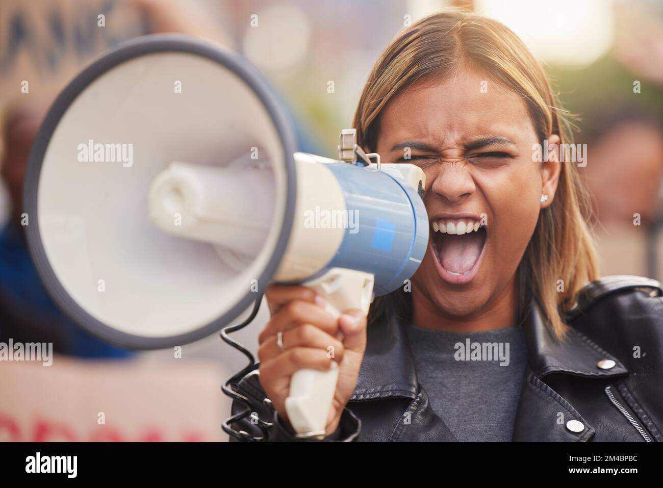 Megáfono, mujer y gritos de cambio social, humanidad y justicia para la igualdad, en la calle y en Póngase en pie. Mujer joven, manifestante y niña hispana Foto de stock