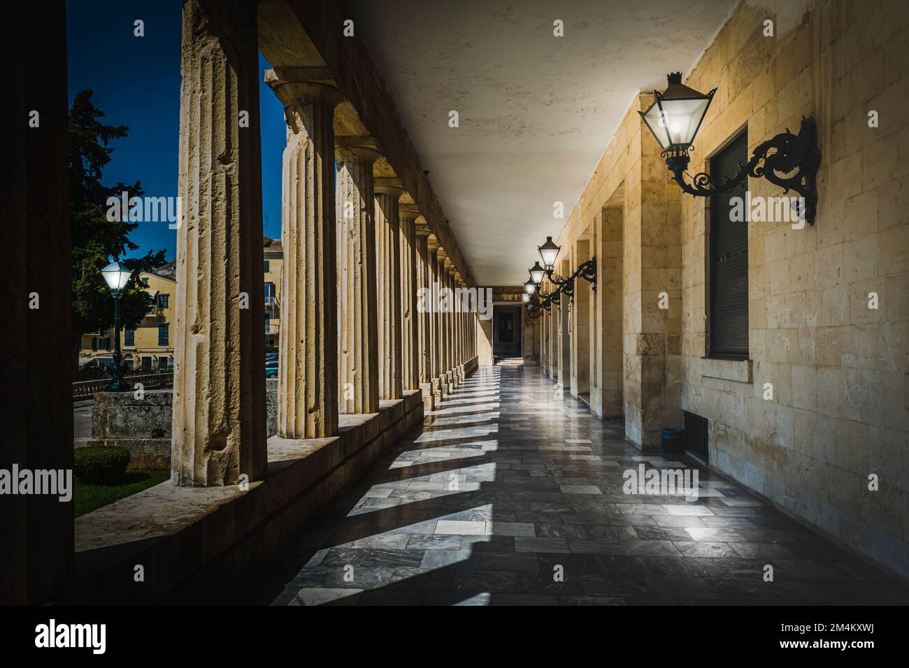 Pasarela cubierta o stoa con columnas griegas y linternas por la noche. Foto de stock