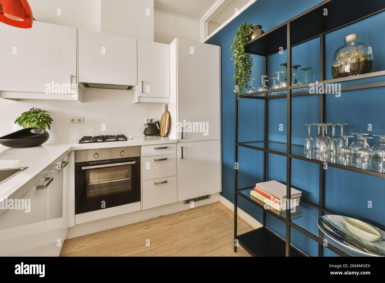 una cocina con paredes azules y armarios blancos en la pared, hay un  televisor montado sobre el fregadero Fotografía de stock - Alamy