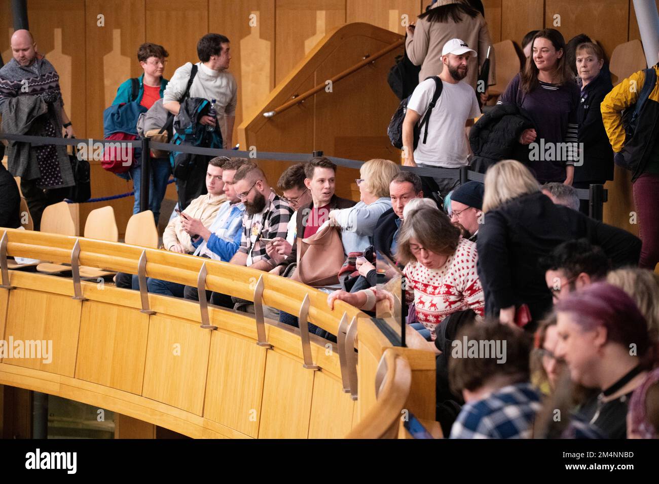 Edimburgo, Escocia, Reino Unido. 22nd de diciembre de 2022. EN LA FOTO: Los defensores de los derechos trans del proyecto de ley celebran después de que se haga el anuncio de que el proyecto de ley ha sido aprobado oficialmente. Ellos animan y agradecen a los MSP abajo en la cámara, quienes a su vez reaccionan mirando su silla hacia la galería y renunciando a ellos. Reacciones dentro de la cámara de debate después de que se apruebe el proyecto de ley de la Etapa 3 sobre la Reforma del Reconocimiento de Género (Escocia). Crédito: Colin D Fisher Crédito: Colin Fisher/Alamy Live News Foto de stock