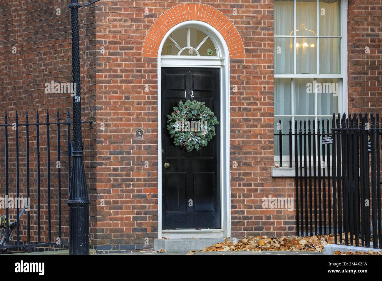 Puerta de entrada a 12 Downing Street, exterior en invierno con corona, Londres, Reino Unido Foto de stock