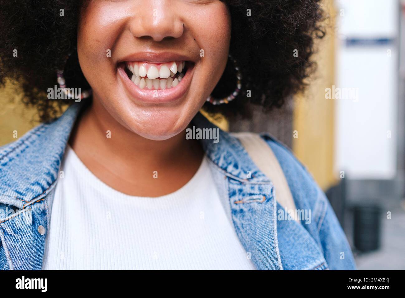 Mujer joven alegre que muestra sonrisa dentada Foto de stock