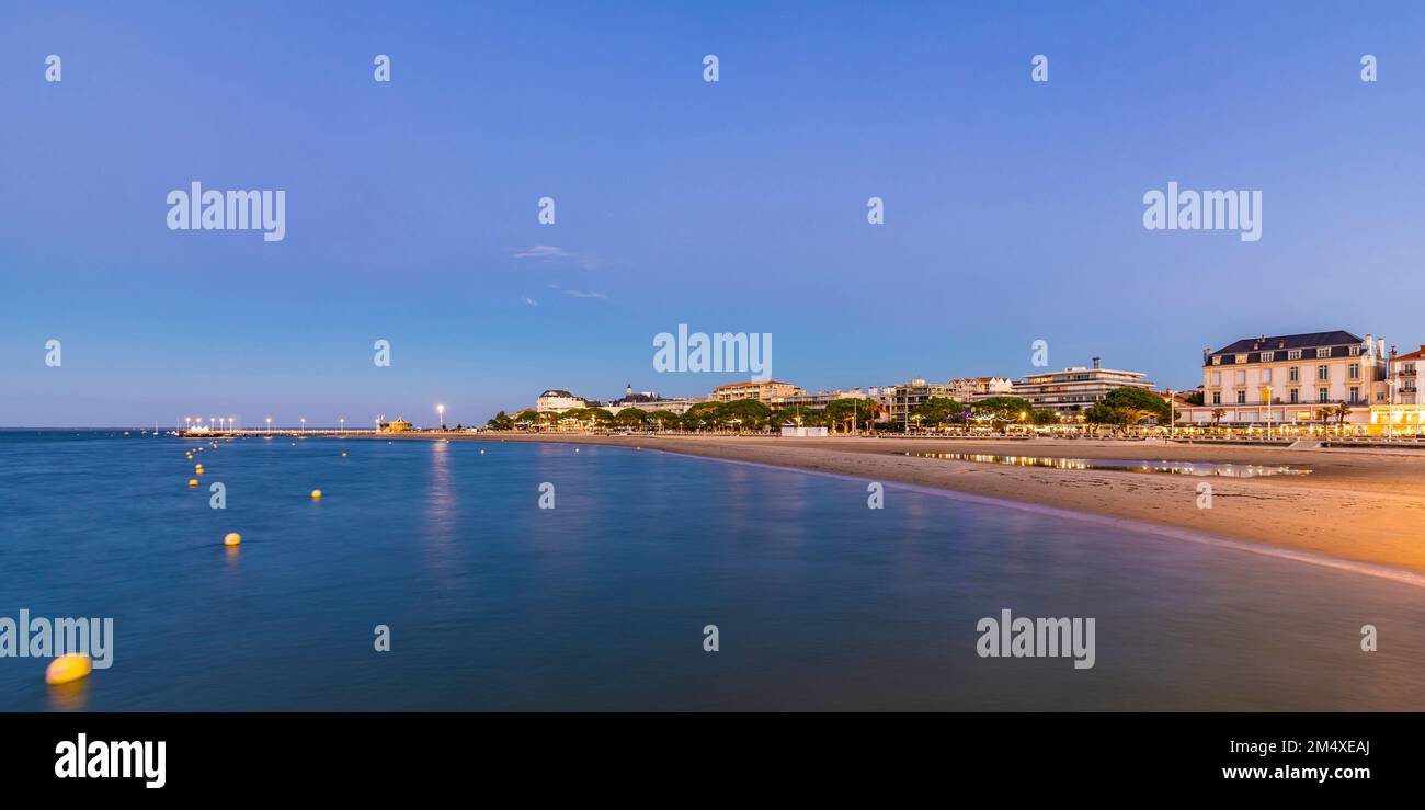 Francia, Nouvelle-Aquitaine, Arcachon, Vista panorámica de la playa vacía de la bahía de Arcachon al atardecer Foto de stock