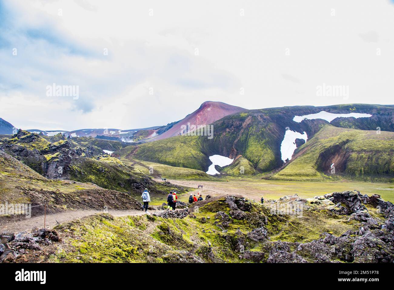 Landmannalaugar, Islandia: 20 de agosto de 2022: Senderismo en la carretera de las tierras altas con nieve y musgo volcánico verde en Landmannalaugar, Islandia Foto de stock
