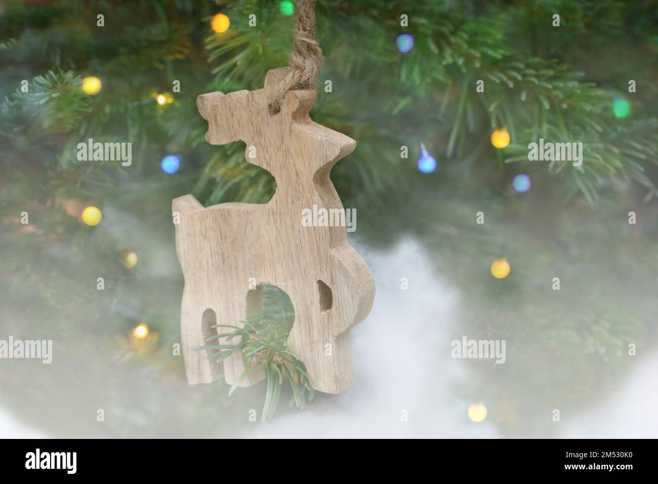 Decoración del árbol de Navidad, una figura de un ciervo de madera sobre un fondo borroso en un formato horizontal Foto de stock