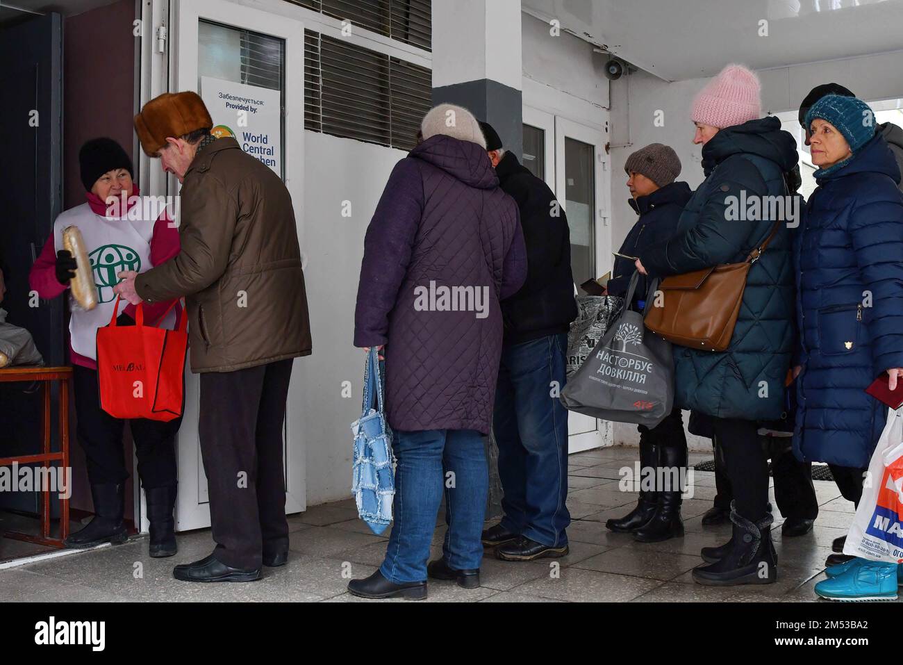 La gente recibe pan en un punto de distribución de ayuda humanitaria en Kramatorsk. Las fuerzas rusas siguen golpeando la infraestructura de energía crítica en las ciudades ucranianas, matando a más civiles y dejando a decenas de miles de personas sin electricidad, mientras sus tropas aumentan el ritmo de sus ataques implacables a lo largo de toda la línea del frente en el este. Foto de stock