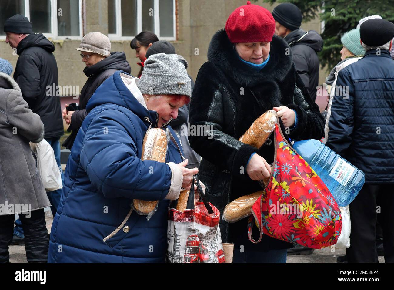 Las mujeres reciben pan en un punto de distribución de ayuda humanitaria en Kramatorsk. Las fuerzas rusas siguen golpeando la infraestructura de energía crítica en las ciudades ucranianas, matando a más civiles y dejando a decenas de miles de personas sin electricidad, mientras sus tropas aumentan el ritmo de sus ataques implacables a lo largo de toda la línea del frente en el este. Foto de stock