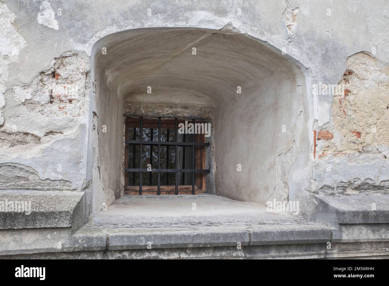 Ventana con rejas en una antigua fortaleza abandonada Foto de stock