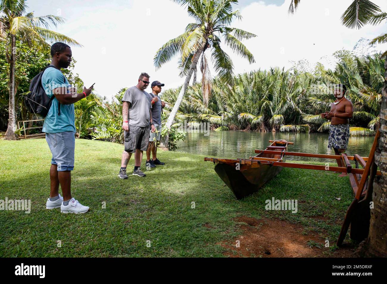 TALOFOFO, Guam (5 de marzo de 2022) Un guía turístico muestra una canoa  tradicional a los marineros, asignada al portaaviones clase Nimitz USS  Abraham Lincoln (CVN 72), como parte de una excursión