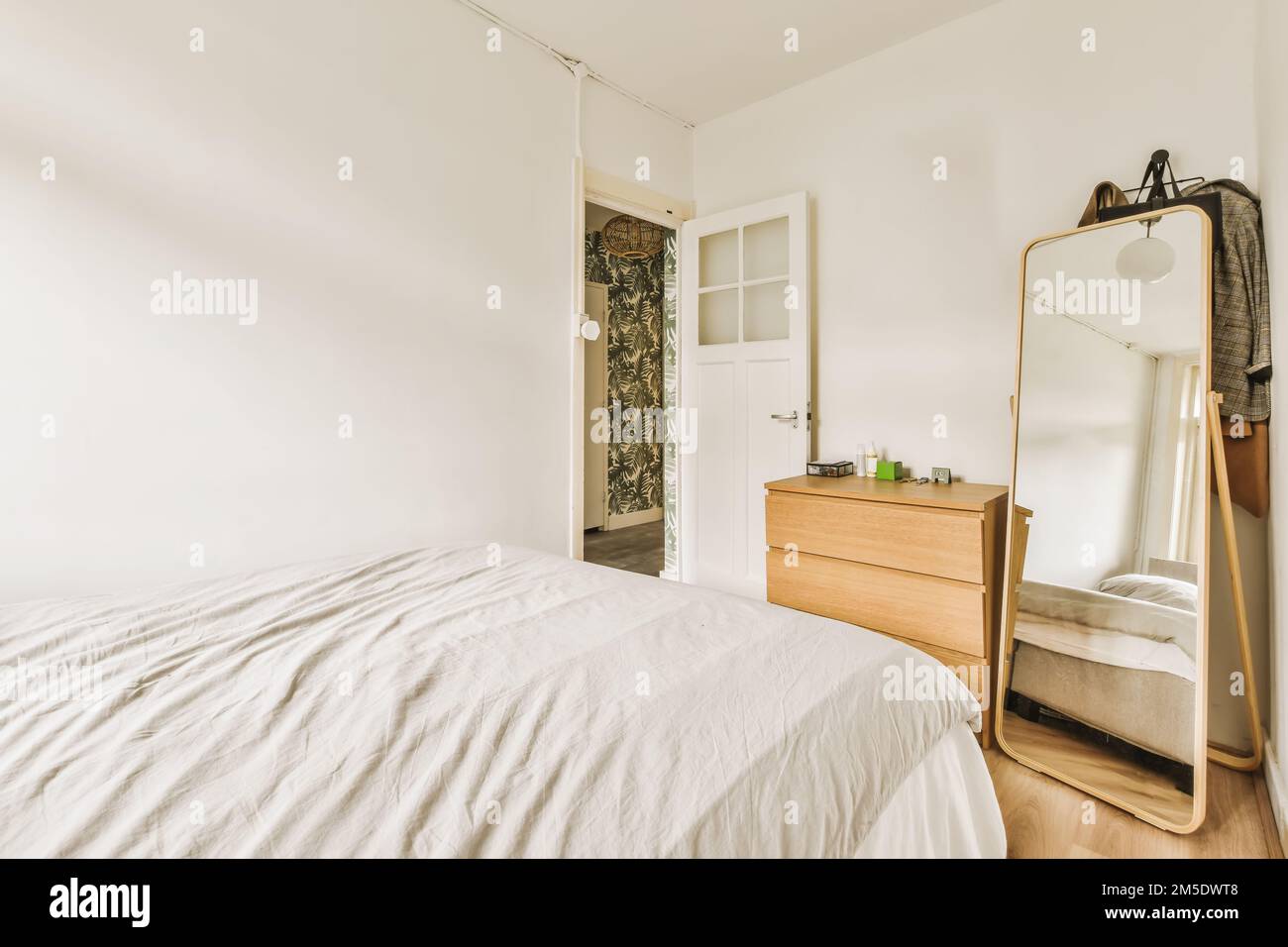 un dormitorio con una cama, escritorio y armarios en la pared al lado es un  armario de cabinetd blanco Fotografía de stock - Alamy