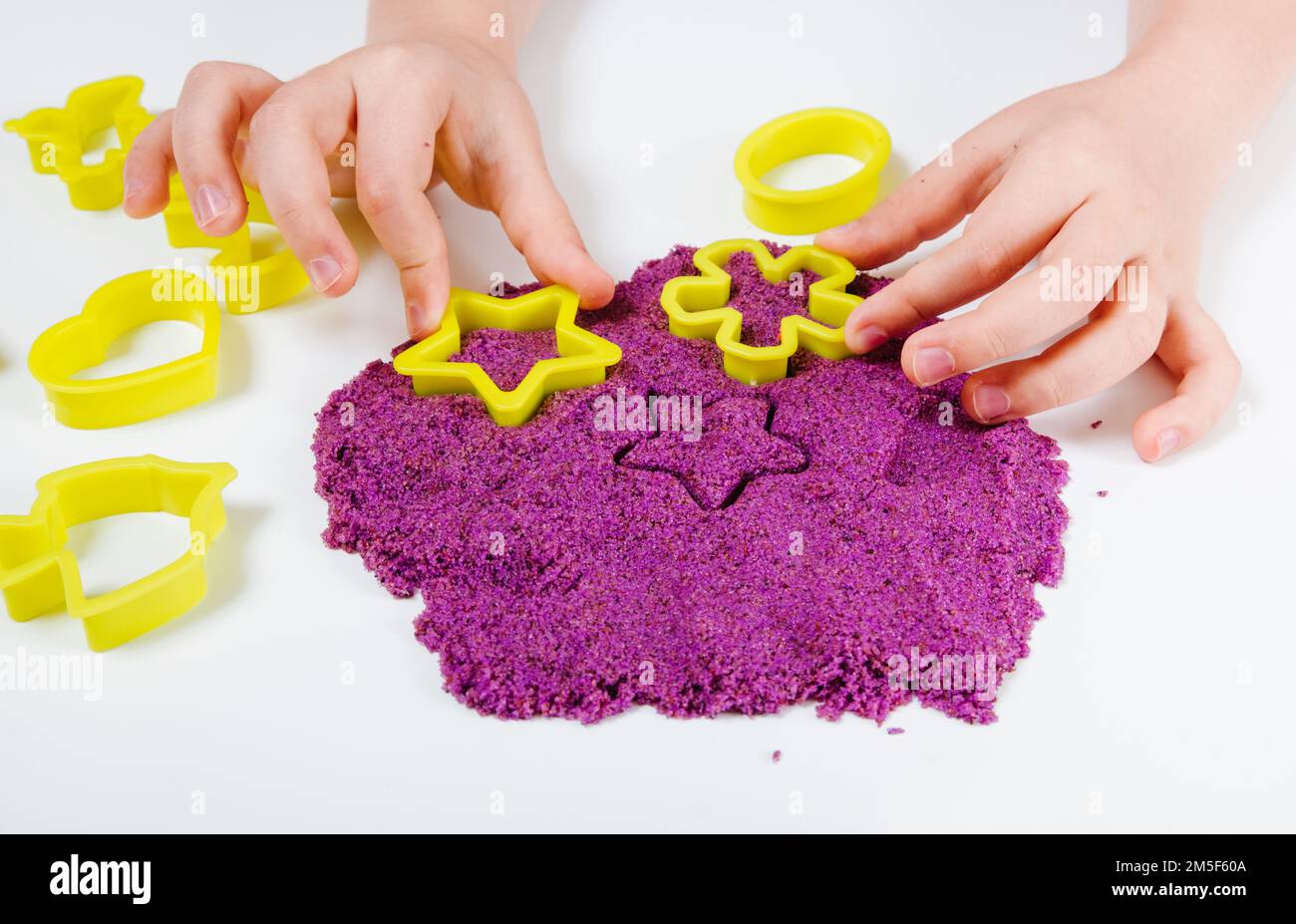 Arena cinética púrpura, moldes de plástico para arena. Niño esculpe y juega  con la arena. Vista de primer plano. Fondo blanco Fotografía de stock -  Alamy