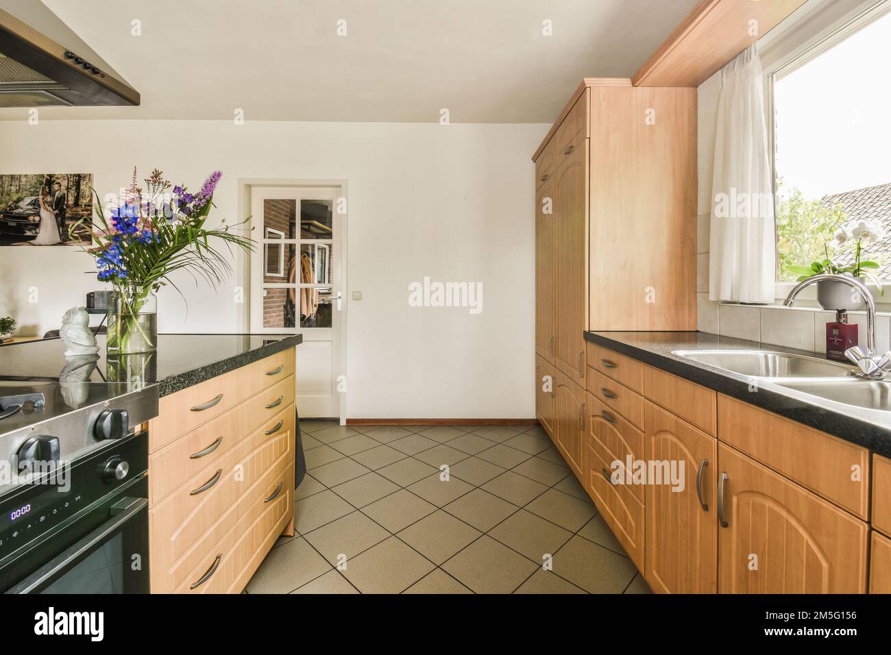 Pisos de vinilo y encimeras de pizarra en un noventa cocina con ventanales  al jardín Fotografía de stock - Alamy