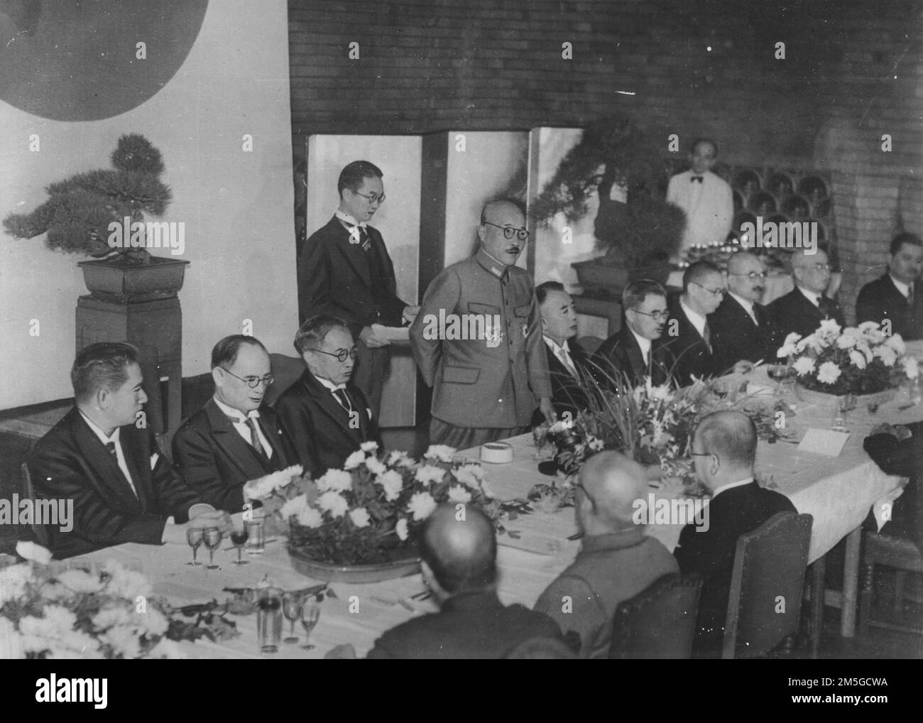 Guerra del Pacífico, 1941-1945. El primer ministro japonés, Hideki Tojo, se dirige a los asistentes durante un banquete con el presidente de la Segunda República Filipina, José P. Laurel, controlado por los japoneses, y los ministros del gabinete japonés, el 1943 de octubre. Foto de stock
