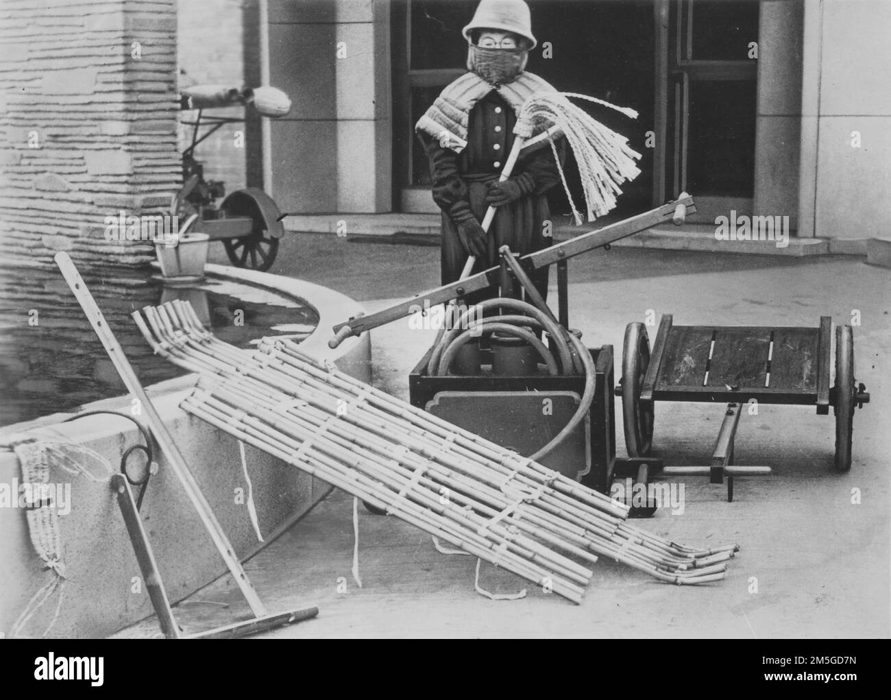 Guerra del Pacífico, 1941-1945. Frente Nacional Japonés - Un voluntario de defensa aérea civil japonés vestido con equipo de lucha contra incendios muestra su equipo utilizado para combatir los incendios resultantes de los ataques aéreos aliados, marzo de 1944. Foto de stock