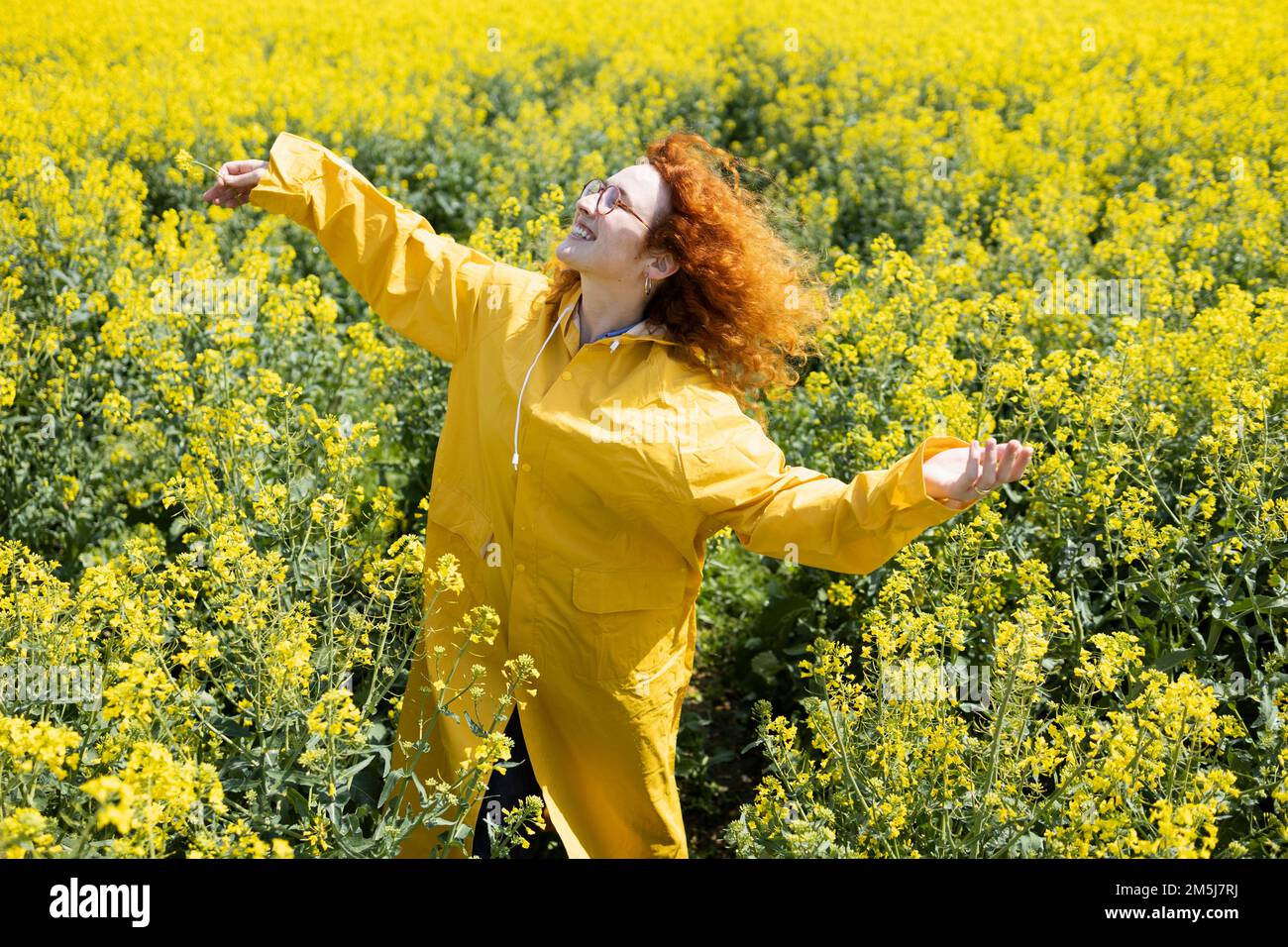 Una mujer disfrutando del calor del sol en un soleado día de primavera Foto de stock