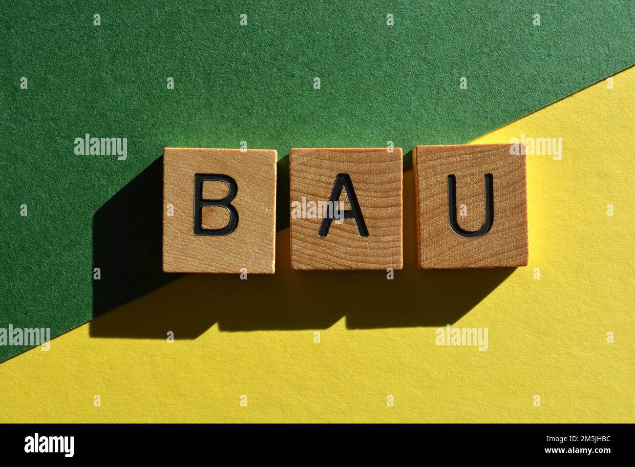 BAU, acrónimo de Business as usual en letras de alfabeto de madera aisladas sobre fondo Foto de stock