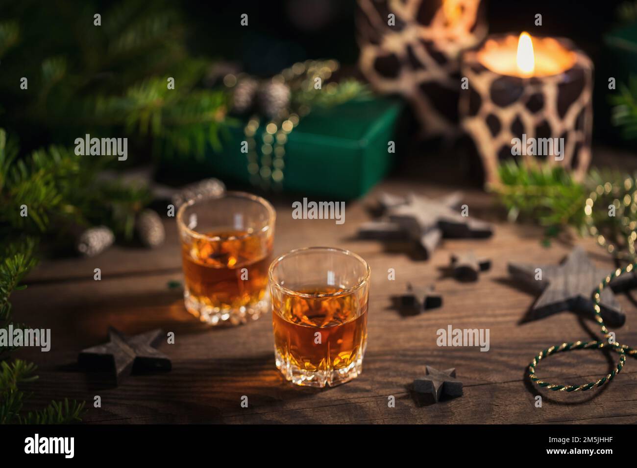 Dos copas de whisky o bourbon con decoración navideña Foto de stock