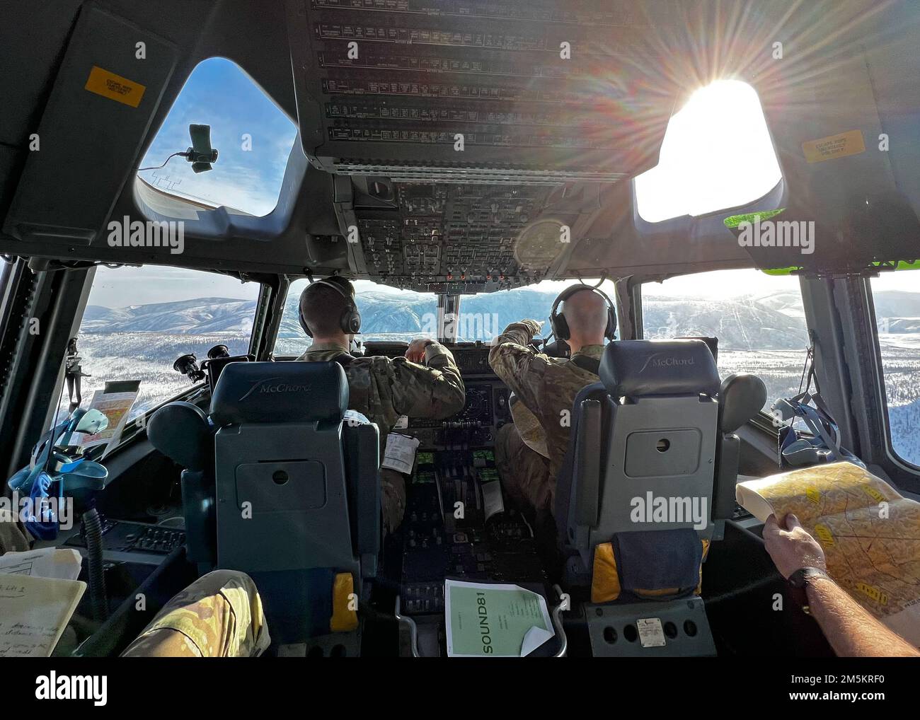 EE.UU El Capitán Ben Basham, izquierda, y el Capitán Dan Wold, ambos pilotos del Escuadrón de Elevación Aérea 8th, vuelan un lanzamiento simulado de bajo nivel en un C-17 Globemaster III para el Ejercicio Rainier War 22A en la Base Conjunta Elmendorf-Richardson, Alaska, 23 de marzo de 2022. Rainier War 22A ejerció y evaluó la capacidad del ala para emplear la fuerza y su capacidad para realizar durante tiempos de guerra y/o tareas de contingencia en un entorno de alta intensidad, disputado en tiempos de guerra, degradado y operacionalmente limitado mientras apoyaba las operaciones de contingencia contra un adversario cercano. Foto de stock