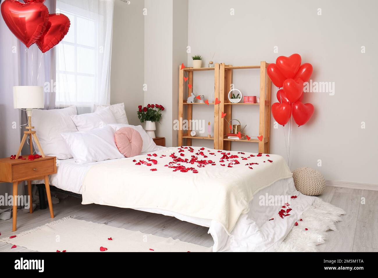 Interior de dormitorio luminoso decorado para el Día de San Valentín con  rosas, mesas y globos Fotografía de stock - Alamy