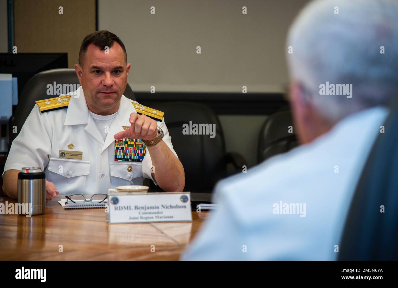 ASAN, Guam (30 de marzo de 2022) - El Contraalmirante Benjamin Nicholson, comandante de la Región Conjunta Marianas (JRM), habla con el Vicealmirante Karl Thomas, comandante de la Flota 7th de los Estados Unidos, durante una llamada a la oficina en la sede del JRM, el 29 de marzo. La Flota 7th de los Estados Unidos lleva a cabo operaciones navales desplegadas en apoyo de los intereses nacionales de los Estados Unidos en el área de operaciones Indo-Asia-Pacífico. Como los EE.UU.. La flota numerada más grande de la Armada, la 7th Fleet, interactúa con otras 35 naciones marítimas para construir asociaciones marítimas que fomenten la seguridad marítima, promuevan la estabilidad y prevengan conflictos. Foto de stock