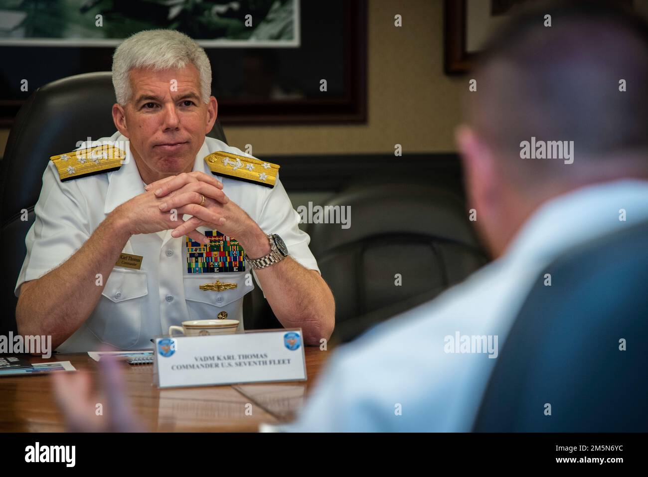 ASAN, Guam (30 de marzo de 2022) - El Contraalmirante Benjamin Nicholson, comandante de la Región Conjunta Marianas (JRM), habla con el Vicealmirante Karl Thomas, comandante de la Flota 7th de los Estados Unidos, durante una llamada a la oficina en la sede del JRM, el 29 de marzo. La Flota 7th de los Estados Unidos lleva a cabo operaciones navales desplegadas en apoyo de los intereses nacionales de los Estados Unidos en el área de operaciones Indo-Asia-Pacífico. Como los EE.UU.. La flota numerada más grande de la Armada, la 7th Fleet, interactúa con otras 35 naciones marítimas para construir asociaciones marítimas que fomenten la seguridad marítima, promuevan la estabilidad y prevengan conflictos. Foto de stock