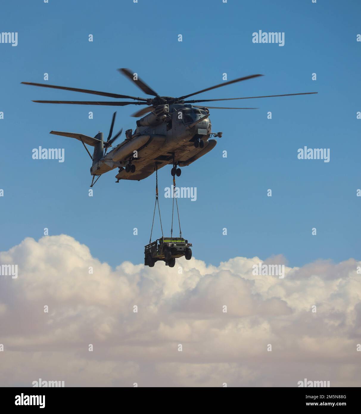 UN EE.UU El Súper Semental CH-53E del Cuerpo de Marines asignado al Escuadrón de Armas y Tácticas de Aviación Marítima Uno (MAWTS-1), realiza un levantamiento externo de un Humvee durante el curso de Instructor de Armas y Tácticas (WTI) 2-22, en el Aeródromo Auxiliar II, cerca de Yuma, Arizona, el 29 de marzo de 2022. WTI es un evento de capacitación de siete semanas organizado por MAWTS-1, que proporciona capacitación táctica avanzada estandarizada y certificación de las calificaciones de los instructores de la unidad para apoyar la capacitación y preparación de la aviación marina, y ayuda en el desarrollo y empleo de armas y tácticas de aviación. Foto de stock