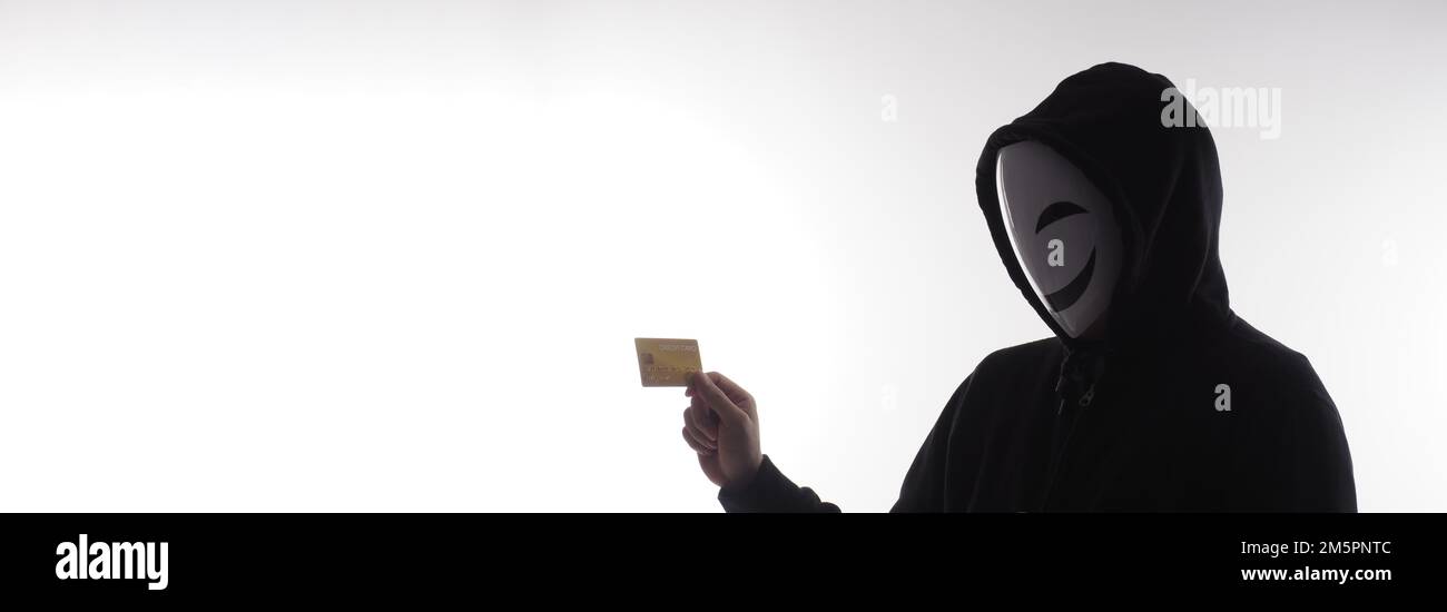 Hacker man y tarjetas de crédito en la mano. Representar los datos personales de las tarjetas de crédito robados por el hombre anónimo en la camisa de capucha negra. Seguridad de datos de tarjetas de crédito y. Foto de stock