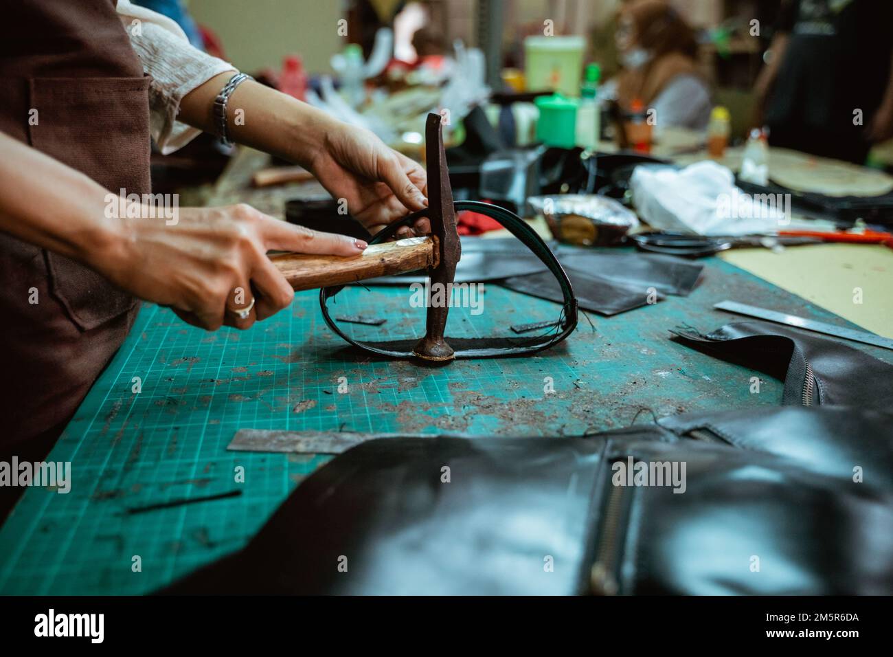 craftsman utiliza el martillo para dar forma a una hendidura de cuero  curtido Fotografía de stock - Alamy