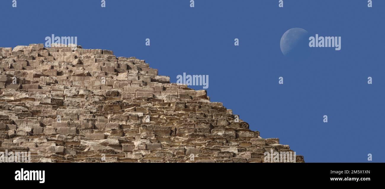 La luna vista detrás de la Pirámide de Khufu, la Gran Pirámide de Giza. Foto de stock