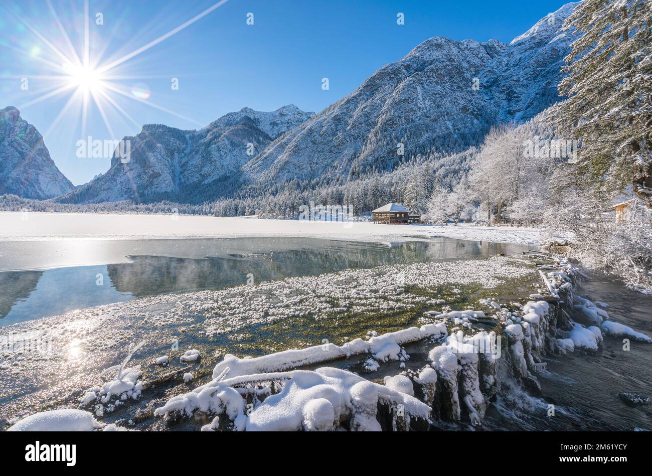 Una mañana soleada de invierno ata nevado y helado lago Dobbiaco, provincia de Bolzano, Trentino Alto Adige, Italia. Foto de stock