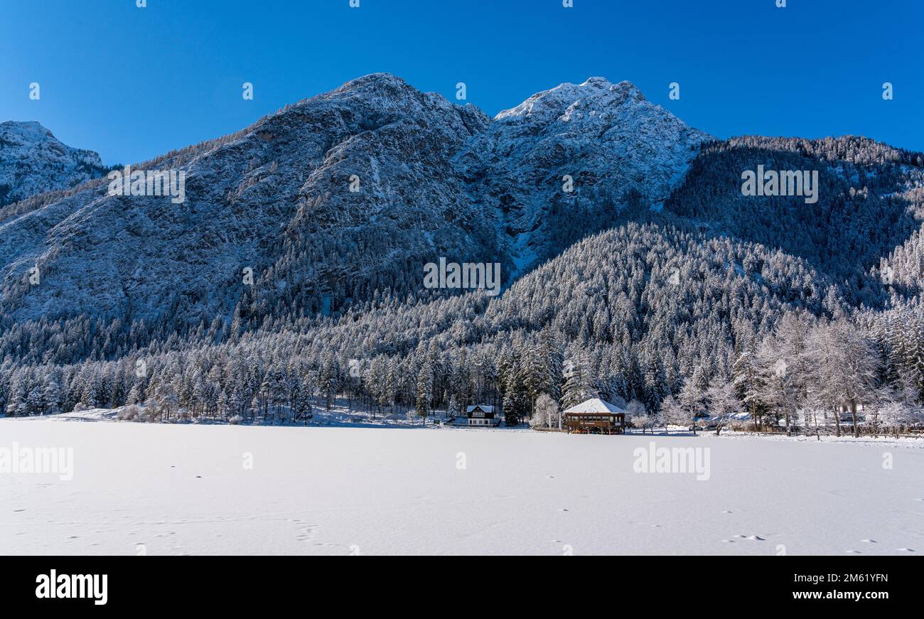 Una mañana soleada de invierno ata nevado y helado lago Dobbiaco, provincia de Bolzano, Trentino Alto Adige, Italia. Foto de stock