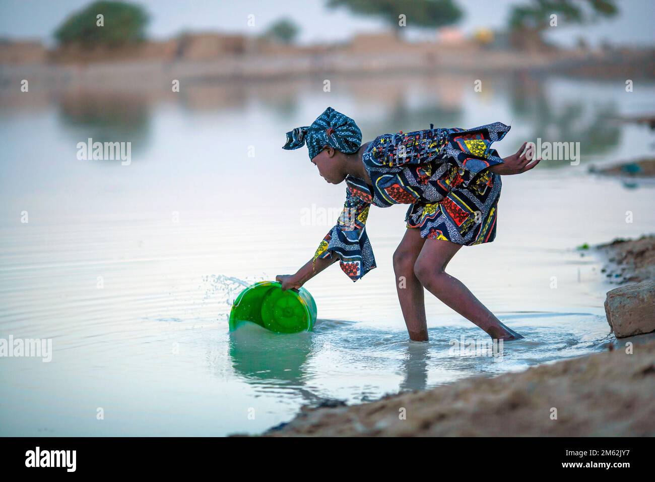 Mujer joven busca agua potable en un pequeño lago en el Léré una pequeña ciudad y comuna rural del Cercle de Niafunké en la región de Tombuctú. Foto de stock