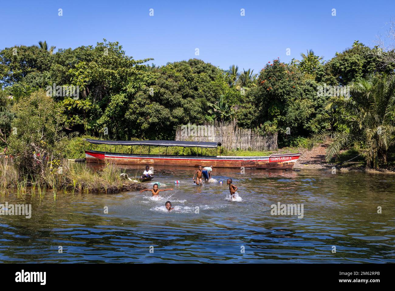 Niños malgaches nadando en el canal de Pangalanes, cerca de Tampina, Madagascar, África Foto de stock