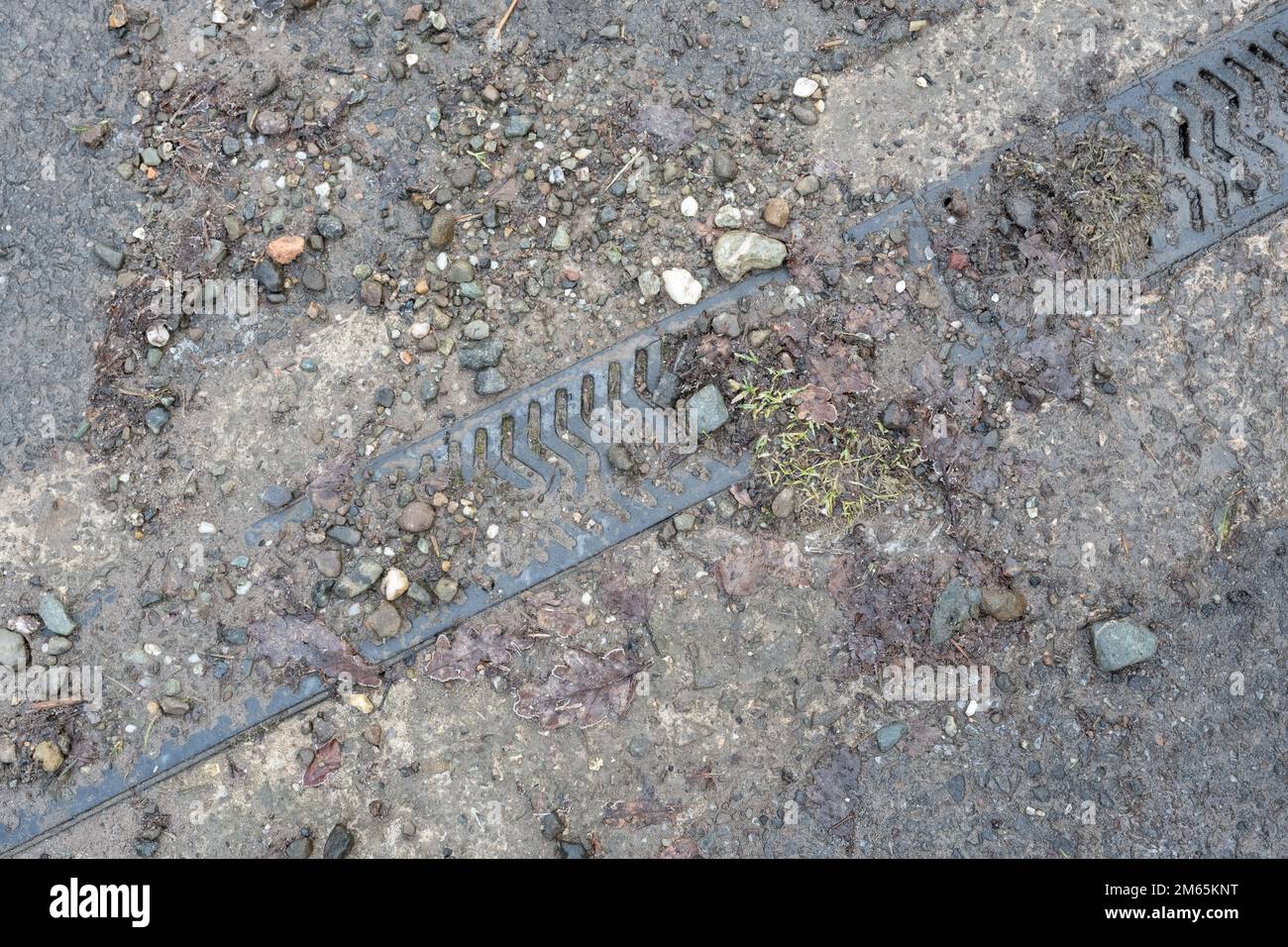 Canal de drenaje o canal de drenaje bloqueado con tierra y grava incapaz de ser utilizado para dirigir el agua de lluvia de la carretera debido a la falta de mantenimiento Foto de stock