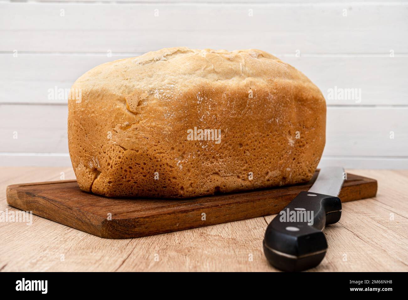 Un pan casero hecho por última vez con una máquina de pan en una tabla de  madera con un cuchillo de pan. Espacio para texto Fotografía de stock -  Alamy