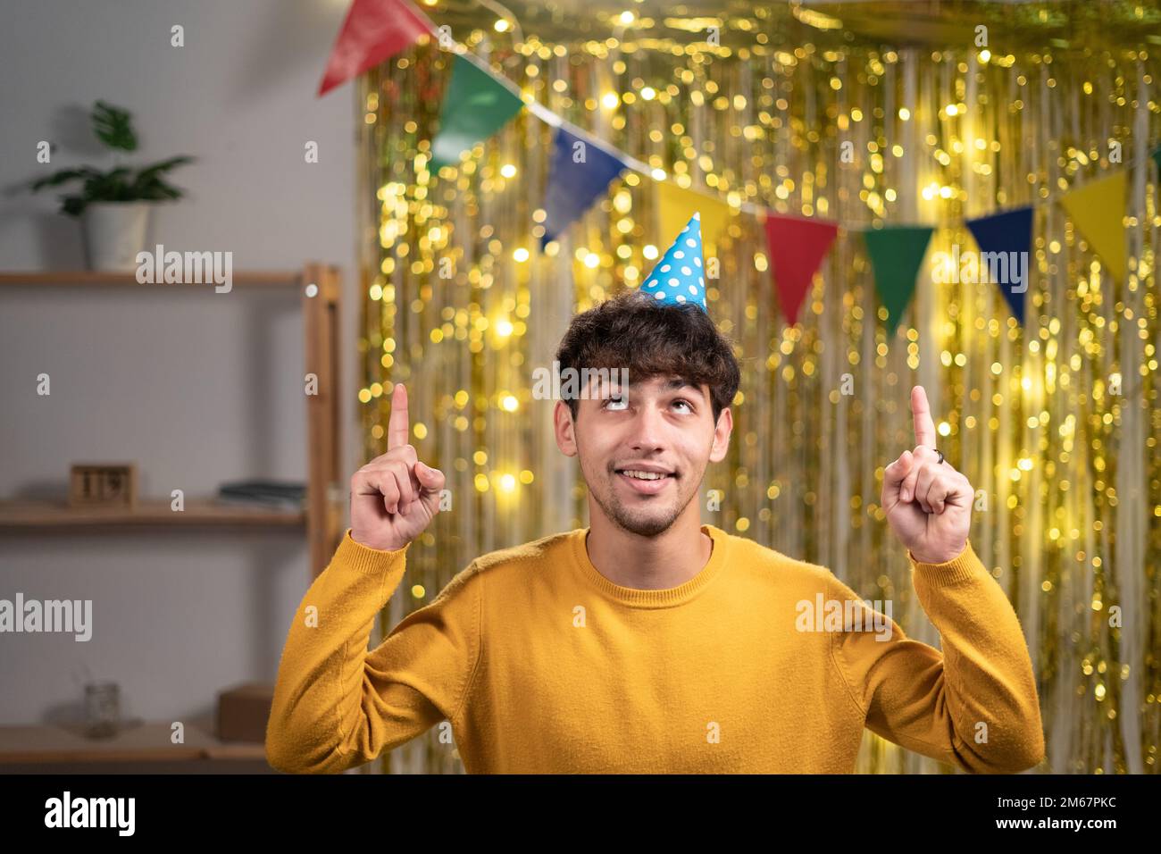 El espacio de copia de los dedos del índice del promotor del tipo positivo árabe sugiere anuncios selectos de la promoción del uso de la ropa elegante, celebrando el cumpleaños en casa b-day Foto de stock