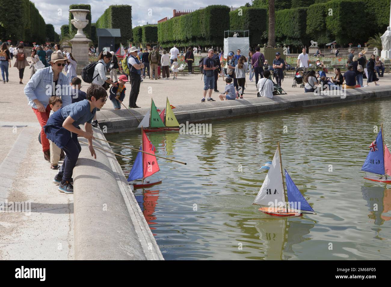 Los niños navegan en el Grand Bassin en el Jardín de Luxemburgo de París en un día de verano Foto de stock