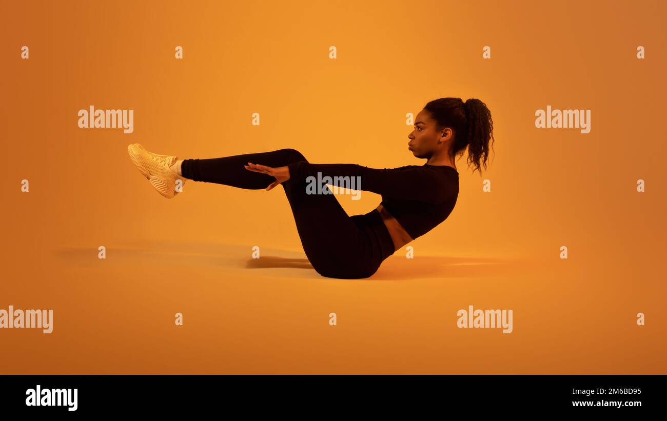 Entrenamiento de fitness. Dama negra activa haciendo ejercicios de abdominales acostado en el