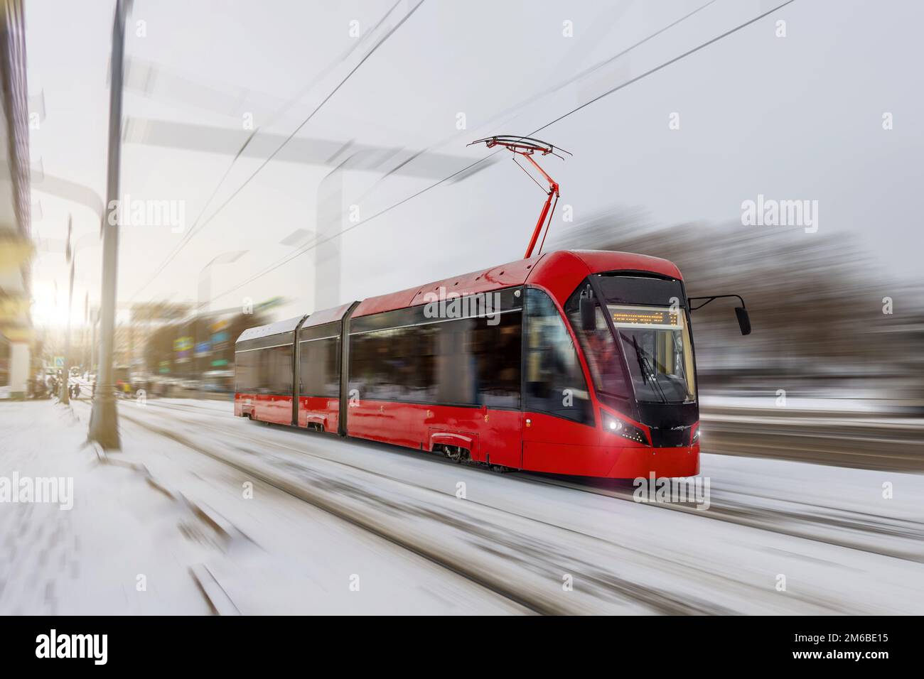 El tranvía rojo corre por la ciudad en efecto de desenfoque de movimiento invernal Foto de stock