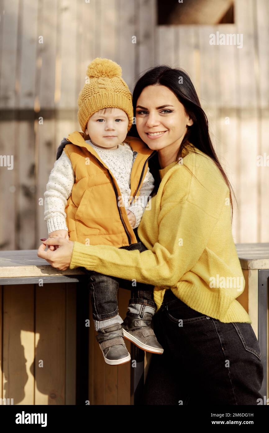 La madre y el bebé se sientan en un banco Foto de stock