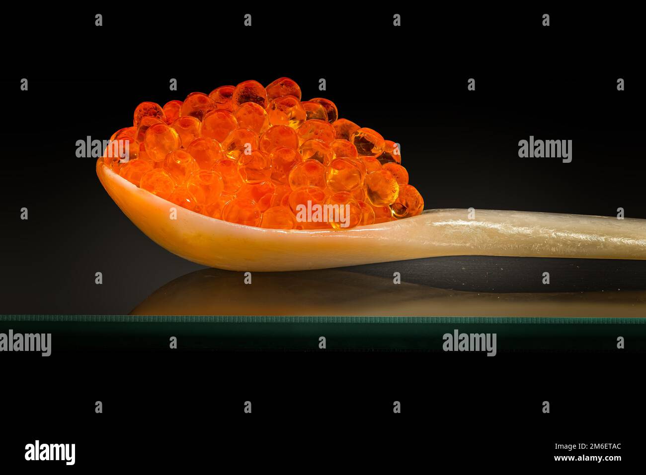 Caviar de salmón fresco en una madre de cuchara de perla Foto de stock